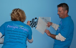 Design Angels volunteers Annette and Kevin Kuester apply a racing flag decal on the bedroom wall