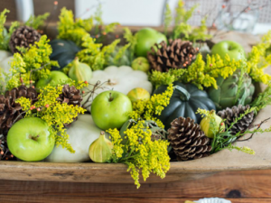 green plants, green apples, and pine cones make the perfect centerpiece for a fall table