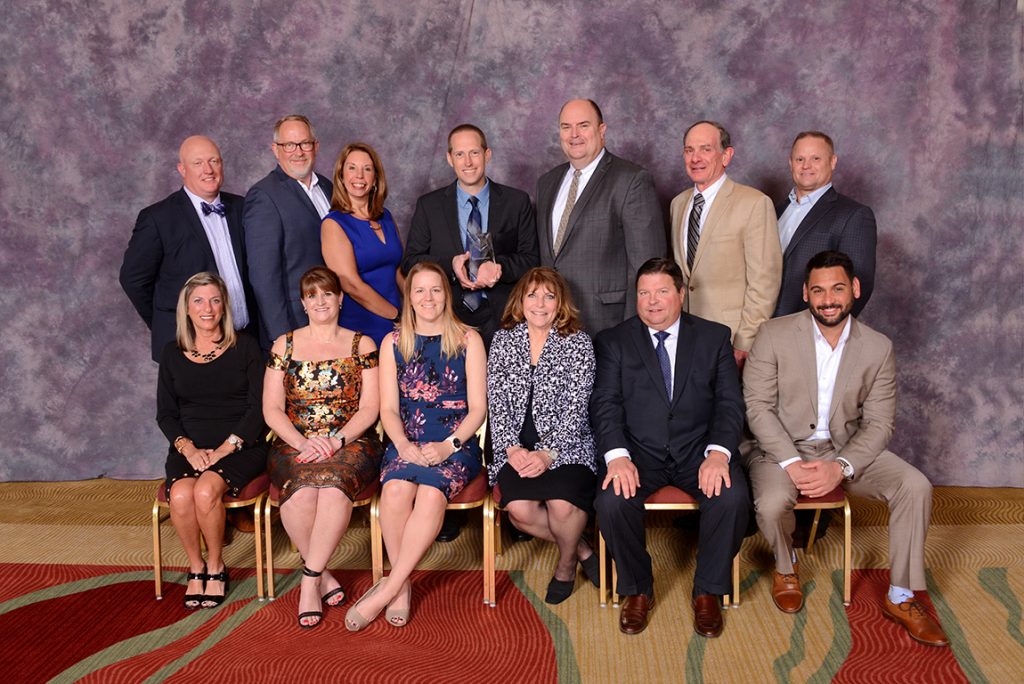 Gary VandenLangenberg (2nd row, center) and Rachel Weber (1st row, third from left) of H.J. Martin &amp; Son were joined by vendor partners in accepting the award.