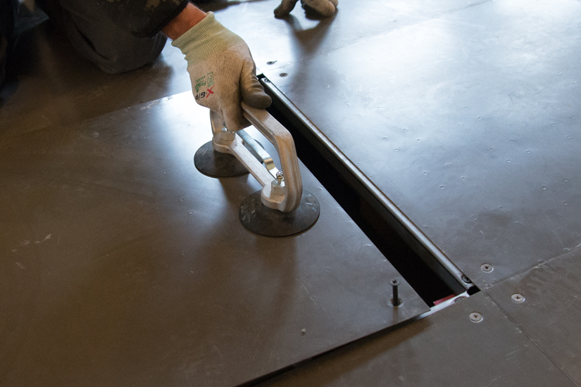 Person lifting an access tile