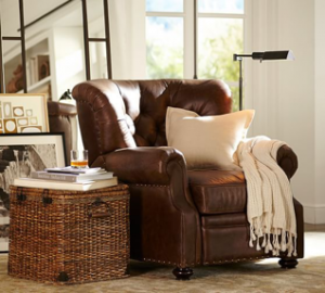 Brown leather couch, white throw pillow and throw blanket, wicker basket side table