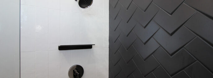 tiled shower with white rectangles and black 3-d diamond tile