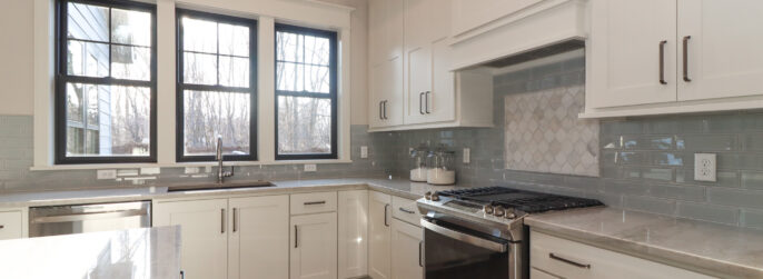 Blue glass kitchen backsplash with white cabinetry